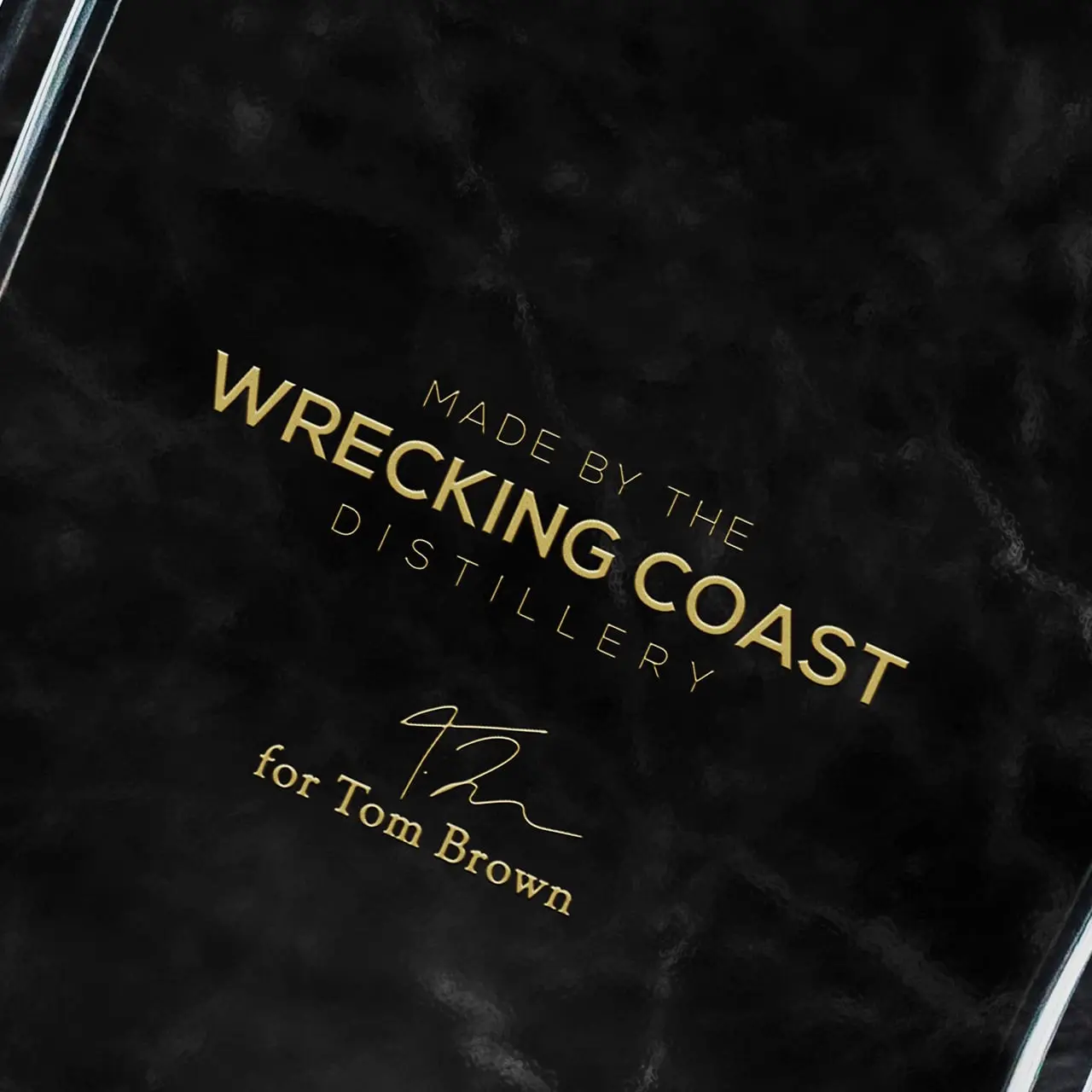 A close-up shot of gin bottle design reading 'Made by the wrecking coast distillery for Tom Brown'