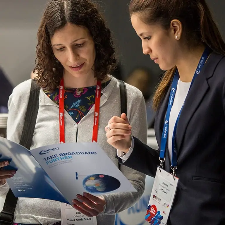 A person discussing the contents of the event brochure with a member of the Konnect team