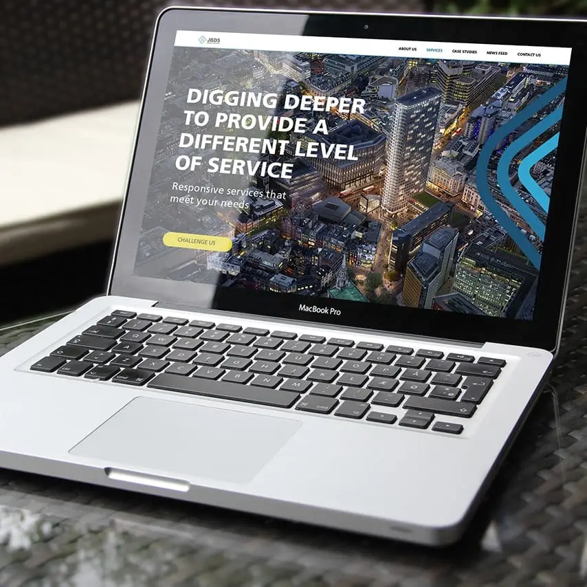 A laptop displaying the designed services webpage of the construction company