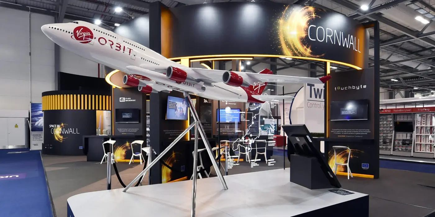 A close up photograph of the Virgin Orbit Cosmic Girl aircraft model at the farnborough international airshow with the exhibition stand design in the background