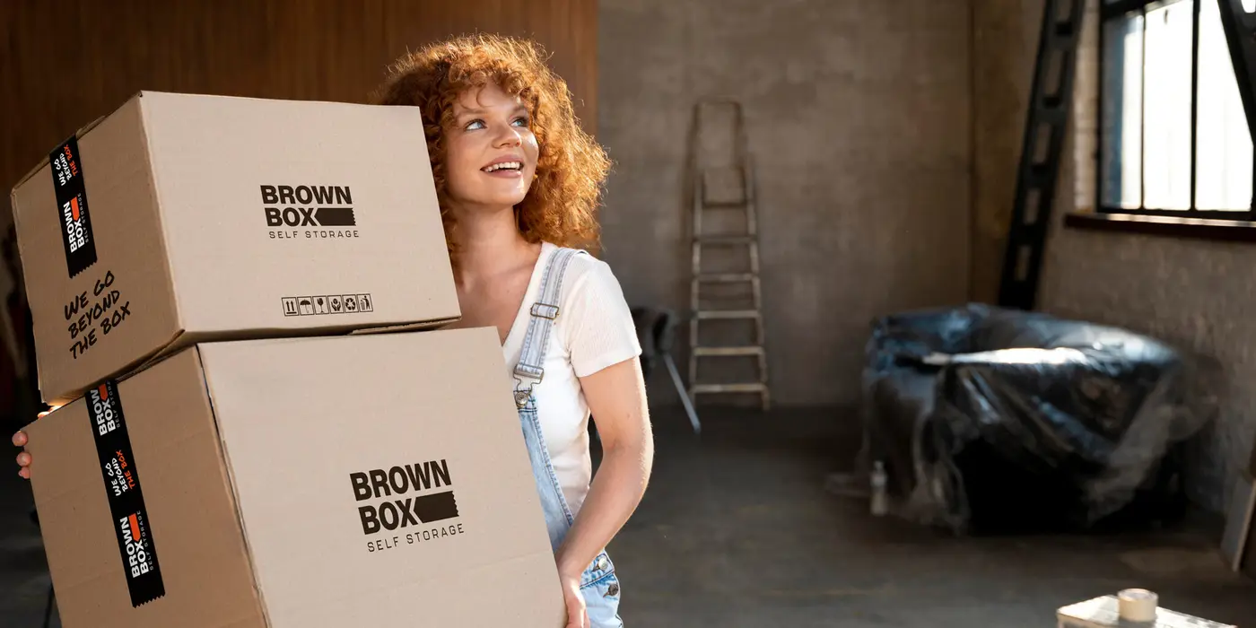 Woman carrying brown cardboard boxes as she is starting a renovation project.