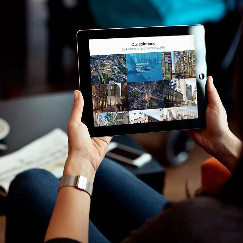 Construction company our work page design as it appears on an iPad being held up by a female