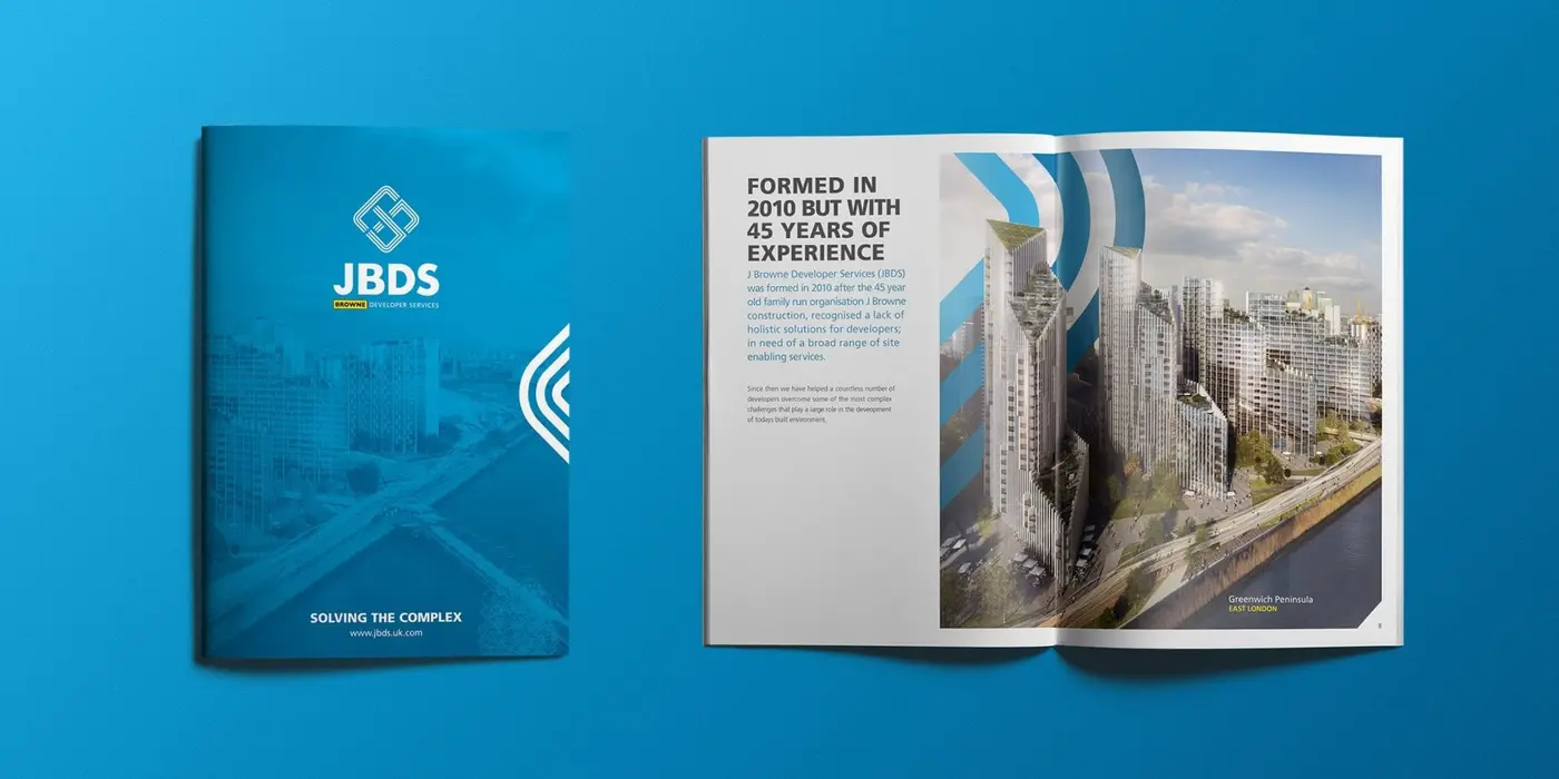 Two brochure shot from above, showing an inside spread and the front cover of the brochure design.